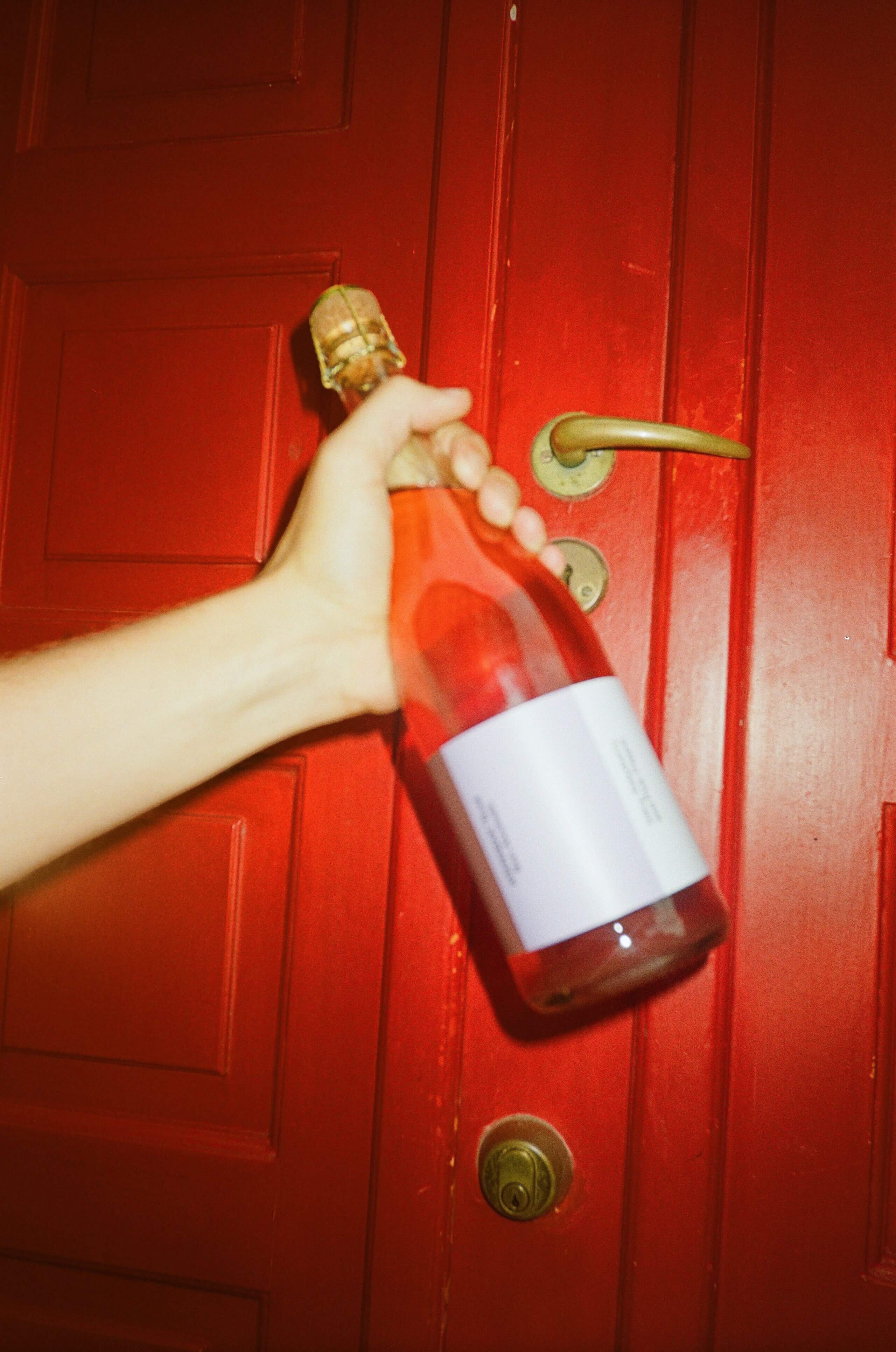 flasche alkoholfrei rosé vor einer roten tür